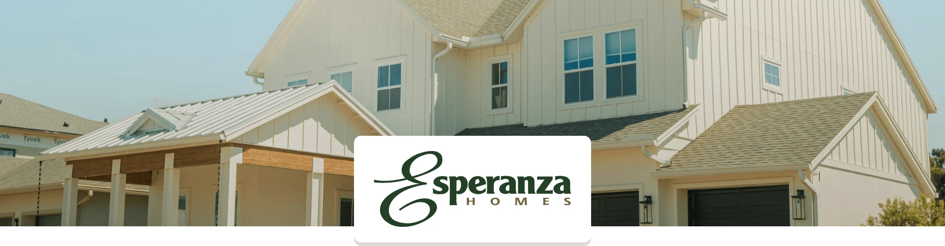 A modern, light-colored house with a gabled roof and attached garages, featuring the Esperanza Homes logo in the foreground.