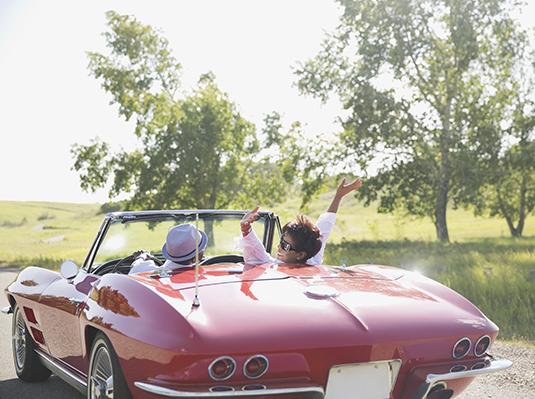 couple sitting in red convertible 