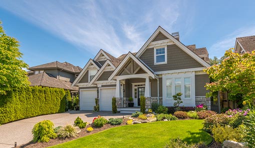 A beautiful home surrounded by a large, well-maintained yard and vibrant landscaping.